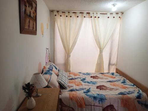 a bedroom with a bed and a window at Hostal CasAlé Usaquén in Bogotá