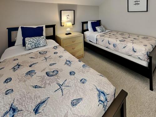 a bedroom with two beds and a dresser with a bed sidx sidx sidx sidx at Baylin B #11B in Topsail Beach