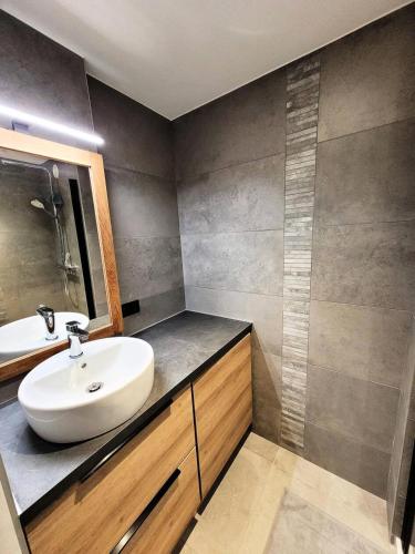 une salle de bain avec un lavabo blanc et un miroir dans l'établissement Résidence Helios - Appartement 2 chambres - vue splendide MAE-1111, aux Gets