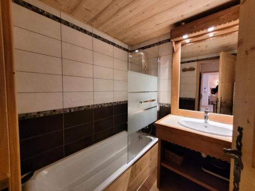 une salle de bain avec une baignoire, un lavabo et un miroir dans l'établissement Résidence Eden Roc Ii - T3 centre station et proche des pistes de ski MAE-1271, aux Gets