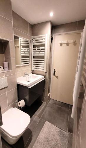 une salle de bain avec un lavabo blanc et des toilettes dans l'établissement Résidence Saint Guibert - Charmant appartement au cœur du vieux village MAE-1341, aux Gets