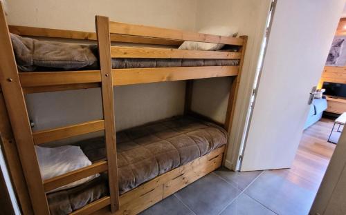 quelques lits superposés dans une chambre dans l'établissement Résidence Saint Guibert - Charmant appartement au cœur du vieux village MAE-1341, aux Gets