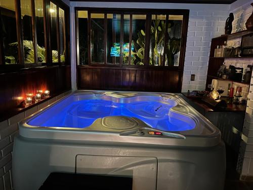 a jacuzzi tub in a room with windows at El Ensueño Ecohostal & Glamping in Mocoa