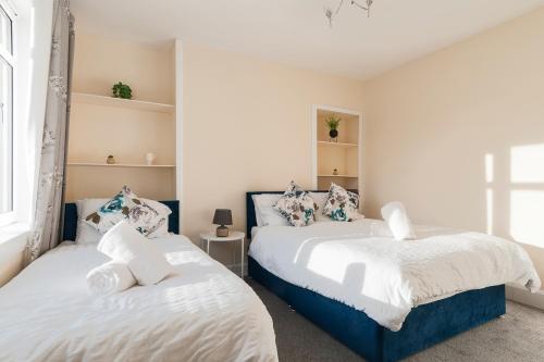 two beds in a room with white and blue at 2 Bed Property, sleeps 5, free parking, near city centre in Edinburgh