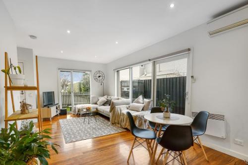 a living room with a couch and a table at Blue Chip Williamstown Beach Bay Townhouse in Williamstown