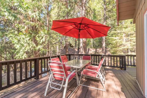 a table and chairs with a red umbrella on a deck at Pops Place in Arnold
