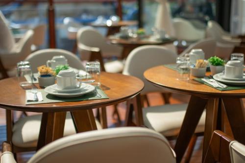 two tables with plates of food on them in a restaurant at Pousada Santa Felicidade in Campos do Jordão