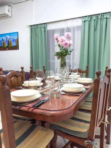 a dining room table with glasses and a vase of flowers at El Oasis in Mendoza