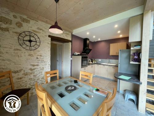 une cuisine et une salle à manger avec une table et des chaises dans l'établissement Gîte rénové avec jardin et terrasse près de Thiré, festival de musique baroque, idéal pour familles - FR-1-426-538, à Bourneau