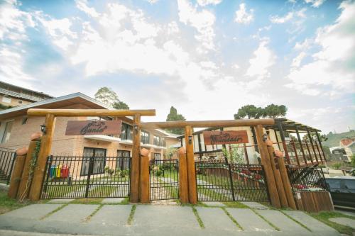 a wooden gate in front of a building at Pousada Santa Felicidade in Campos do Jordão
