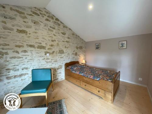 une chambre avec un lit et une chaise bleue dans l'établissement Gîte rénové avec jardin et terrasse près de Thiré, festival de musique baroque, idéal pour familles - FR-1-426-538, à Bourneau