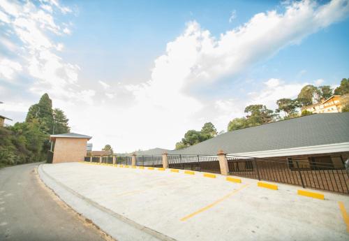a building with a large concrete driveway at Pousada Santa Felicidade in Campos do Jordão