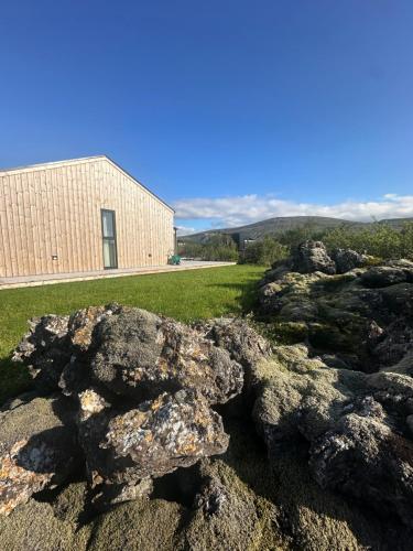 a pile of rocks in front of a building at Modern and family friendly Chalet with Ouside Spa - Birta Rentals in Húsafell