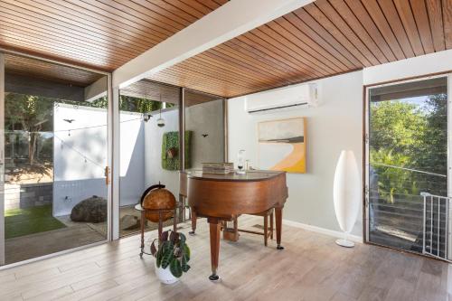 a home office with a desk and a piano at Mid-century Masterpiece With Pool , Spa & Bbq in Escondido