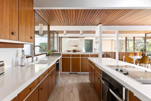a kitchen with wooden cabinets and white counter tops at Mid-century Masterpiece With Pool , Spa & Bbq in Escondido