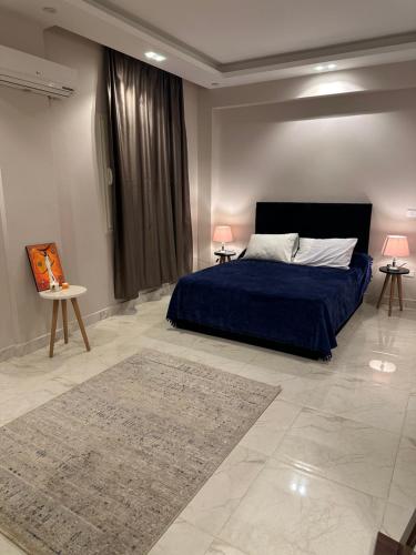 Un dormitorio con una cama azul con dos lámparas y una alfombra. en غرفة مستر بحمام فى التجمع الخامس رجال فقط, en El Cairo