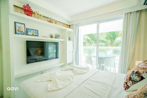 a bedroom with a bed with a tv and a window at In Mare Bali Resort Beira Mar by Qavi - 213 in Granja Beira Mar