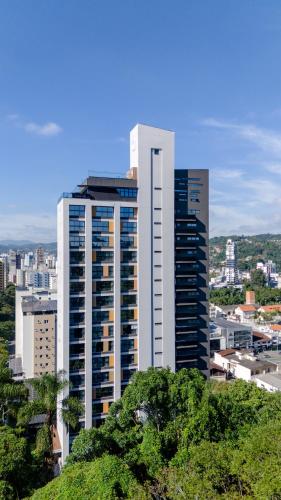 a tall white building in front of a city at Loft próximo a Vila Germânica e FURB com vaga. in Blumenau