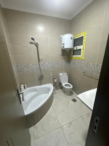 Un baño con bañera, inodoro y lavabo. en غرفة مستر بحمام فى التجمع الخامس رجال فقط, en El Cairo