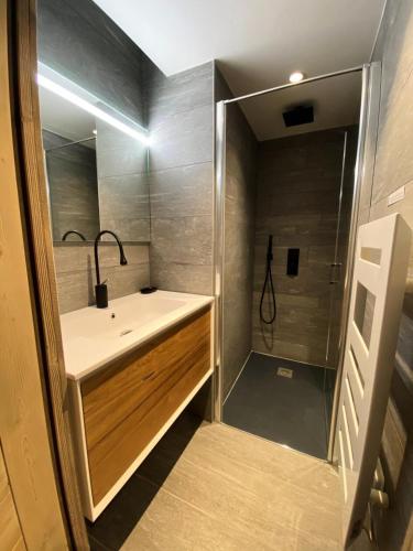 une salle de bain avec un lavabo et une douche dans l'établissement Chalet 1839 - Superbe appartement coeur de station, pied des pistes MAE-0901, aux Gets