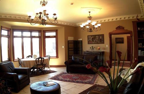 a living room with furniture and a chandelier at Lake Karapiro Lodge in Tirau