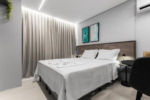 a bedroom with a large bed with white sheets at Alta Garden Housi João Pessoa by Carpediem in João Pessoa