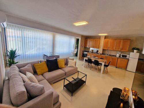 a living room with a couch and a kitchen at Firstfloorby22 in Matosinhos