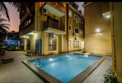 una grande piscina di fronte a un edificio di Goan Hideaway Uno a Siolim