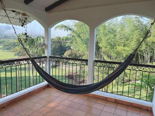 a hammock on a screened in porch with a view at El Rincón De La Abuela Paisaje y Confort in La Cumbre