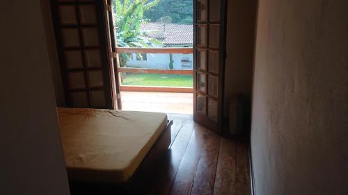 an open door of a room with a bench in front of a window at Casa Helena Barequeçaba in São Sebastião