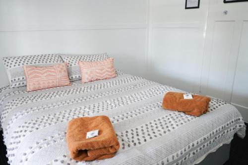 a white bed with two towels on top of it at Queensland Hotel in Goondiwindi