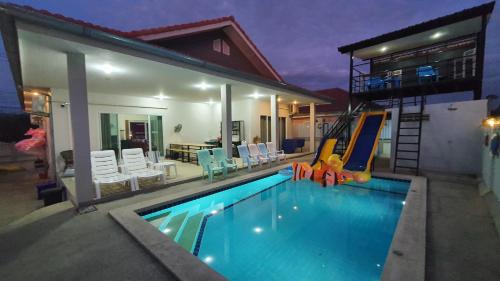 a swimming pool with a slide in a house at Family Pool Villa Chaam in Cha Am