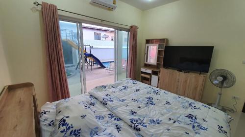 a bedroom with a bed and a sliding glass door at Family Pool Villa Chaam in Cha Am