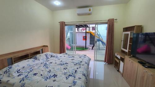 a bedroom with a bed and a flat screen tv at Family Pool Villa Chaam in Cha Am