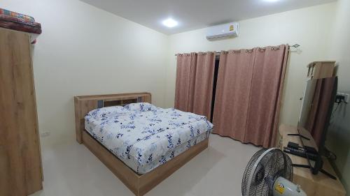 a small bedroom with a bed and a fan at Family Pool Villa Chaam in Cha Am
