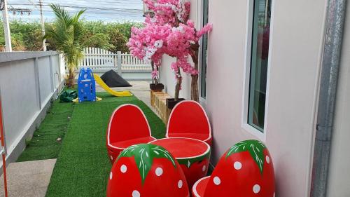 a balcony with two red chairs and a play area at Family Pool Villa Chaam in Cha Am