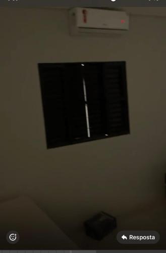 a window in a white wall with blinds on it at Tina Lazer in Jataí