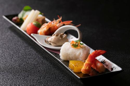a plate of food with sushi and shrimp on a table at Ureshino Motoyu in Ureshino