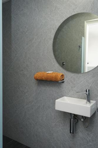 a bathroom with a mirror and a sink at Queensland Hotel in Goondiwindi