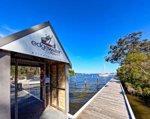 a building on a dock next to a body of water at Edgewater Terraces at Metung in Metung