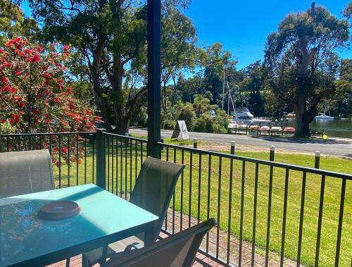 a table and chairs on a balcony with a view of a park at Edgewater Terraces at Metung in Metung