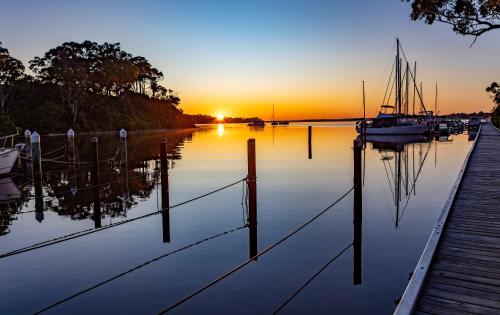 a sunset over a marina with boats in the water at Edgewater Terraces at Metung in Metung