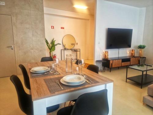 a dining room with a table with chairs and a television at Firstfloorby22 in Matosinhos