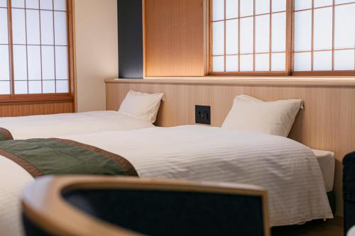 two beds in a room with two windows at Ureshino Motoyu in Ureshino