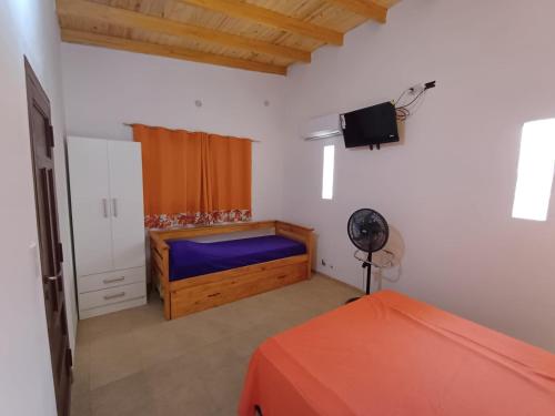 ein Schlafzimmer mit einem Bett und einem Fernseher in der Unterkunft Los Luises - Departamentos Céntricos in Mina Clavero