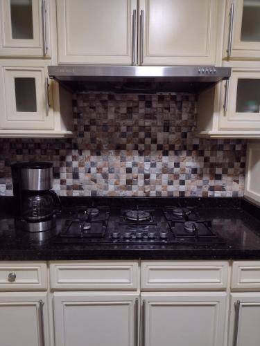 a kitchen with white cabinets and a stove top oven at Casa La Riviera in Santa Rosa de Cabal