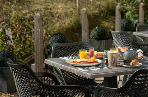 a table with plates of food and drinks on it at voco Winchester Hotel & Spa by IHG in Winchester