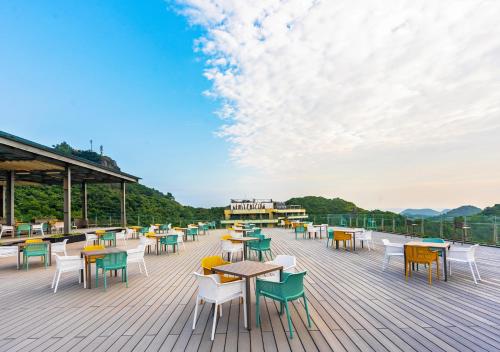 a deck with tables and chairs on a building at Flamingo Resort Cat Ba in Cat Ba
