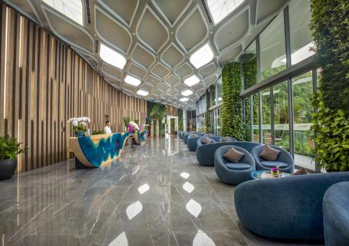 a lobby with blue couches and plants in a building at Flamingo Resort Cat Ba in Cat Ba