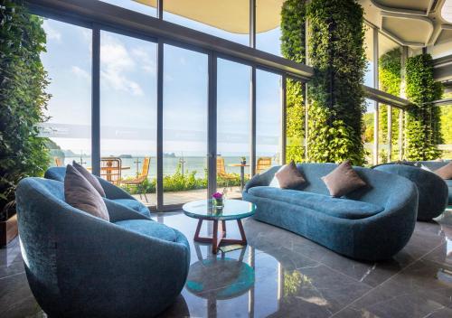 a living room with blue couches and a table at Flamingo Resort Cat Ba in Cat Ba